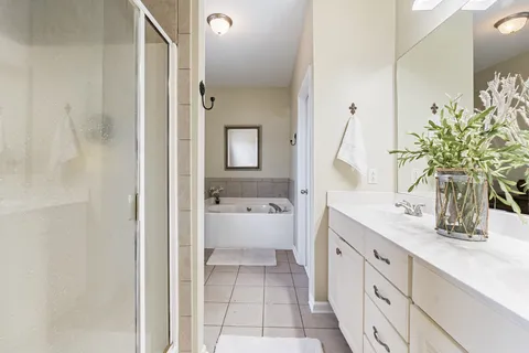 a spacious bathroom with a double vanity sink a mirror and a shower