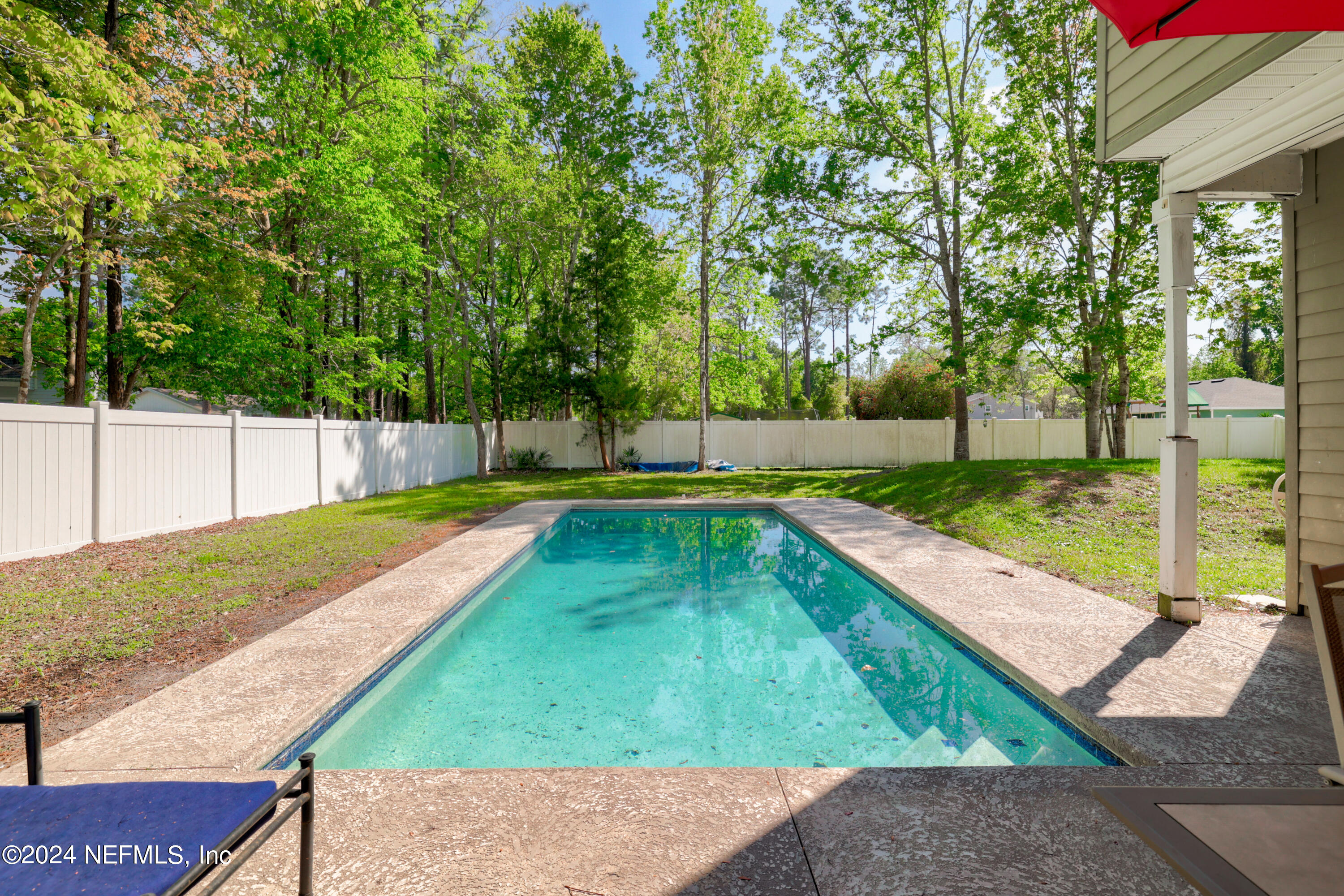 a view of backyard with swimming pool and seating space