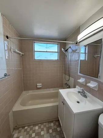 a bathroom with a sink mirror toilet and bathtub