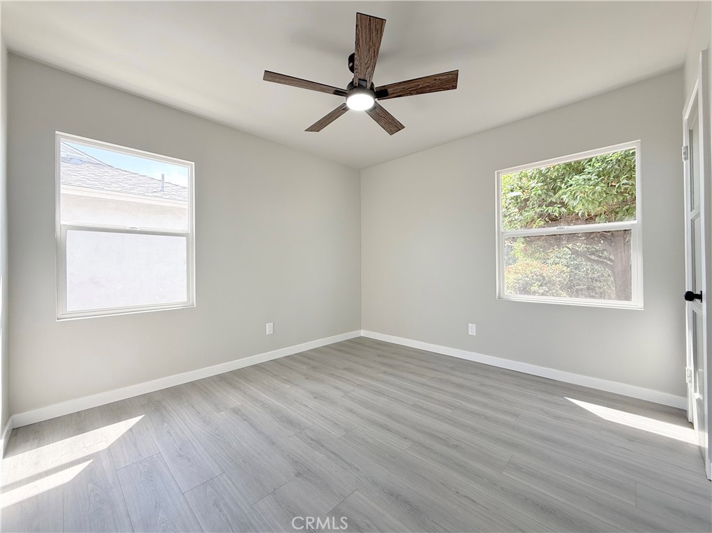 1506 West Stockwell Street Compton, CA 90222 - Photo 12 of 20 an empty room with wooden floor windows and fan
