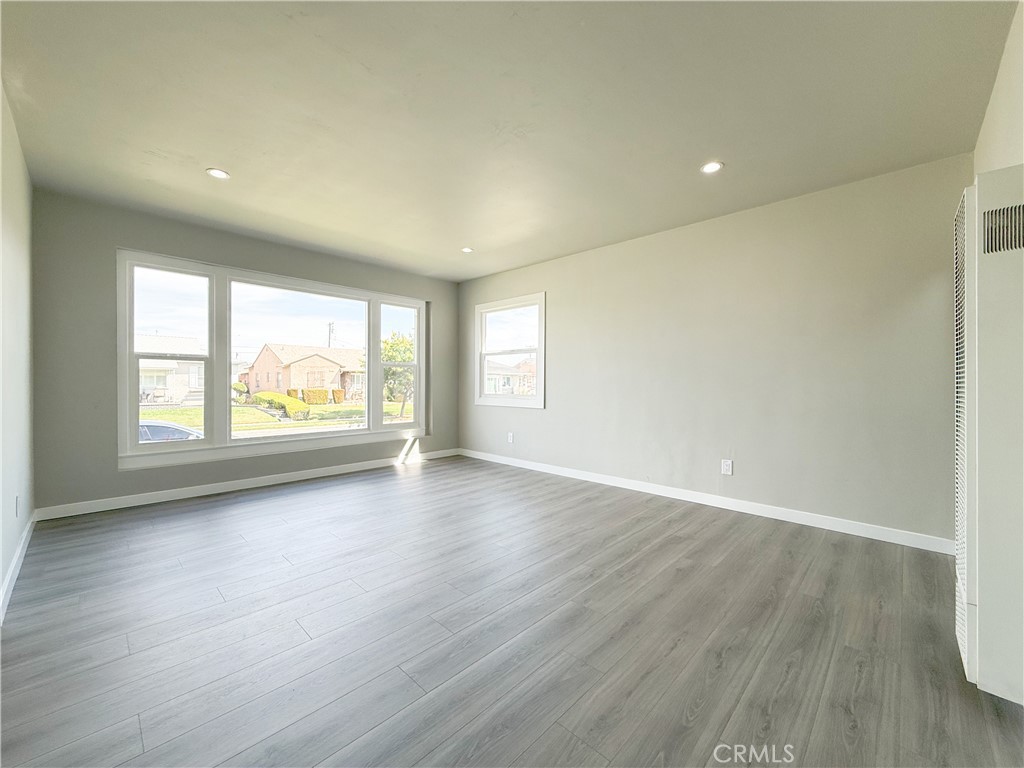 1506 West Stockwell Street Compton, CA 90222 - Photo 4 of 20 an empty room with wooden floor and windows