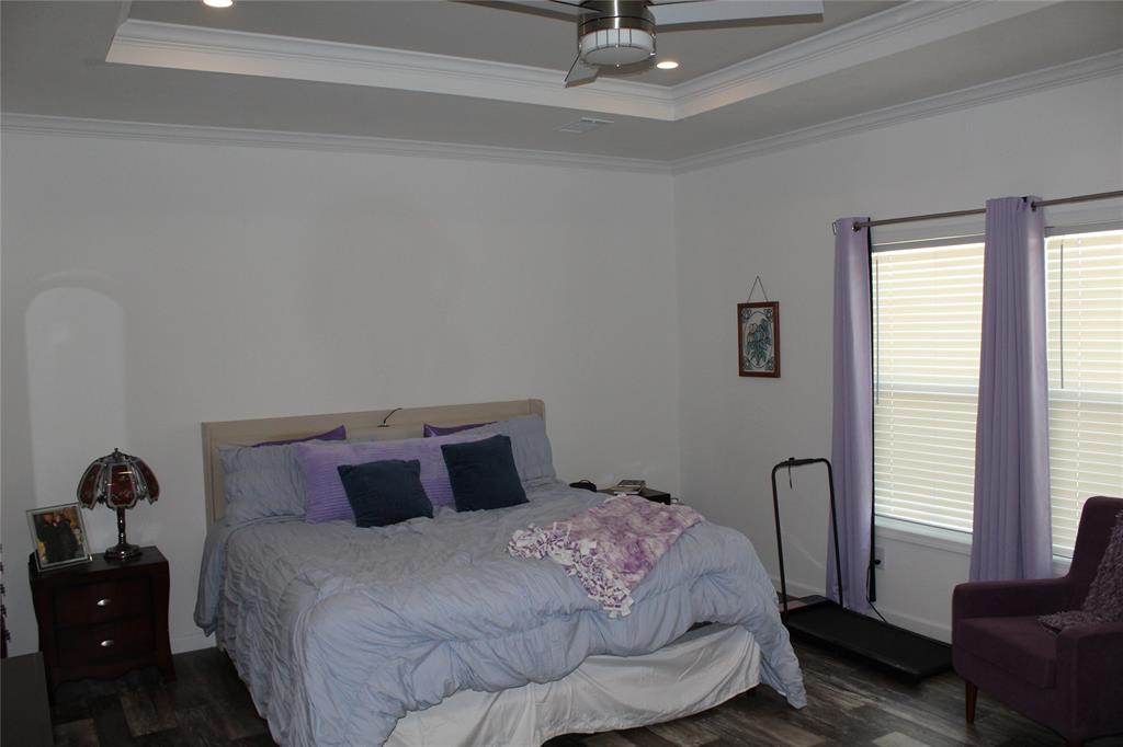 2077 A Shawver Road Perrin, TX 76486 - Photo 11 of 35 a bedroom with a bed and wooden floor