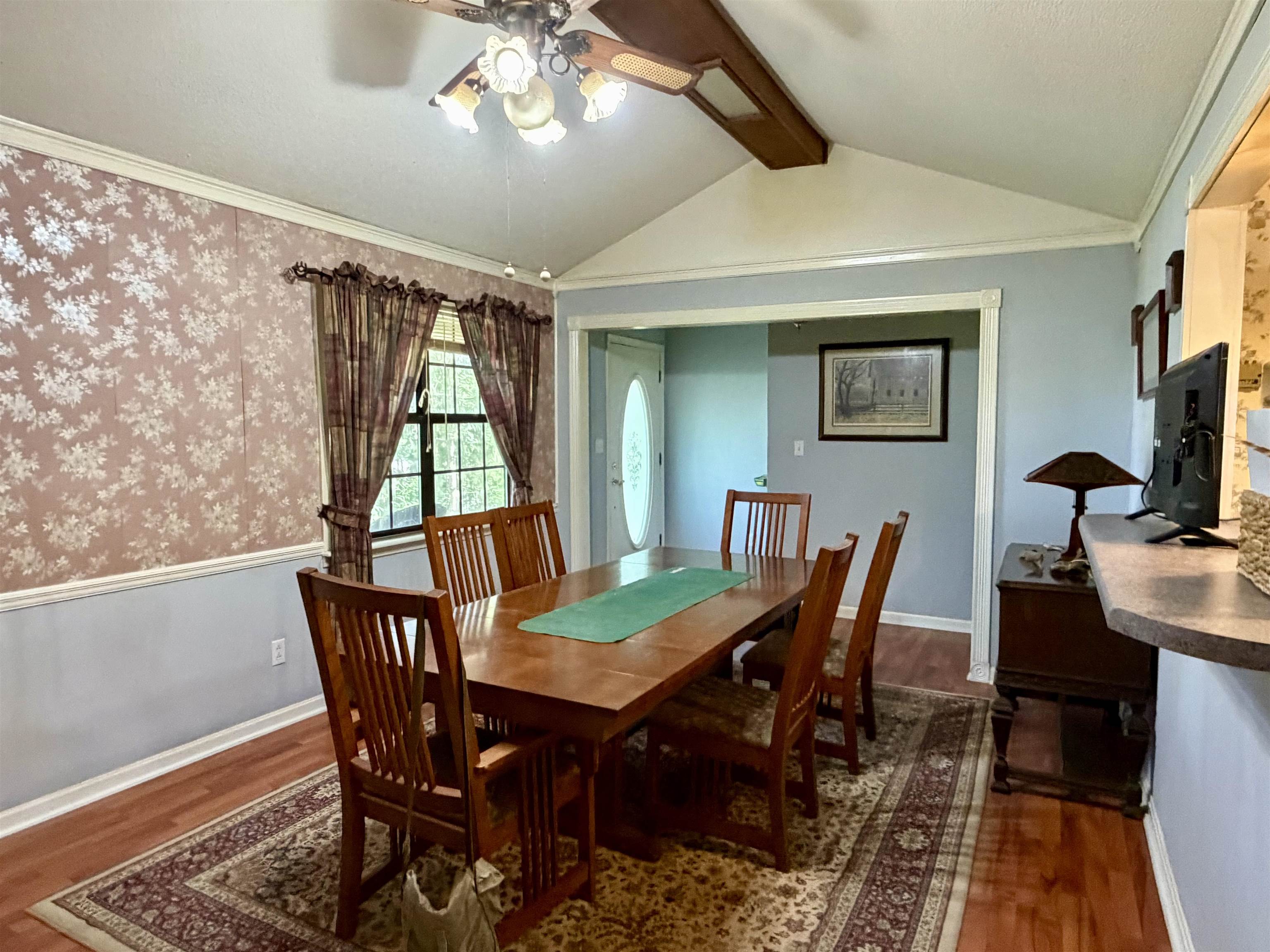373 Clarence Barham Road Bethel Springs, TN 38315 - Photo 5 of 28 Room featuring a vaulted ceiling with a ceiling fan, wood-finish flooring, and a window with trim