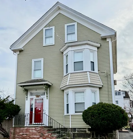 a view of a house with a small yard and a large window