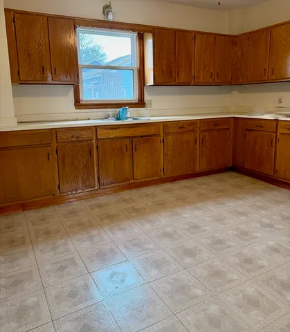 a view of a kitchen with stainless steel appliances granite countertop a stove a sink and a microwave
