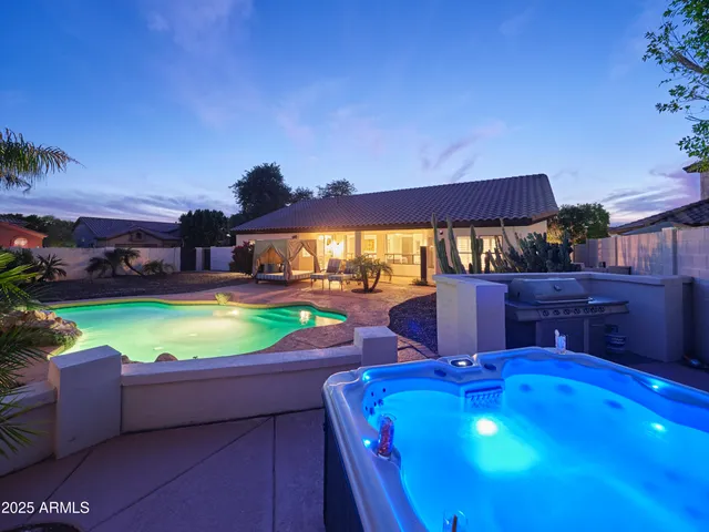 a view of a swimming pool with lawn chairs under an umbrella