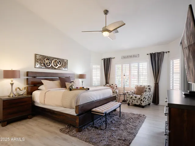 a bedroom with a bed a window and a chandelier