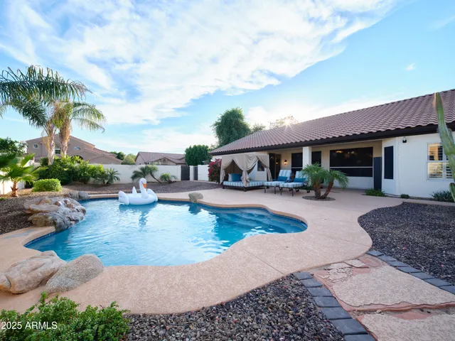 a view of a patio with couches and a table and chairs under an umbrella