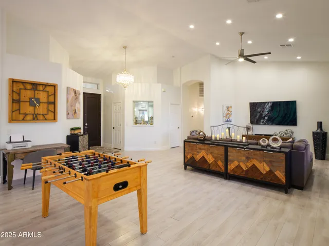 a living room with large mirror furniture and a flat screen tv