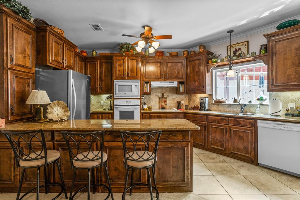 110 Bent Creek Ranch Court Fort Worth, TX 76126 - Photo 32 of 40 a kitchen with stainless steel appliances granite countertop a sink and cabinets