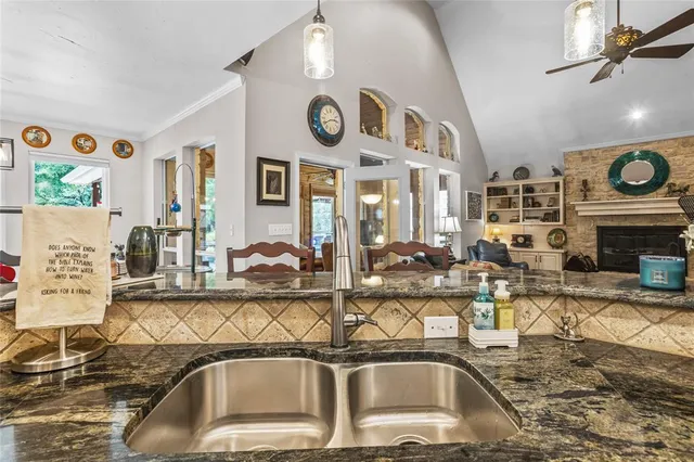 a view of a kitchen with stainless steel appliances granite countertop a sink and a stove top oven