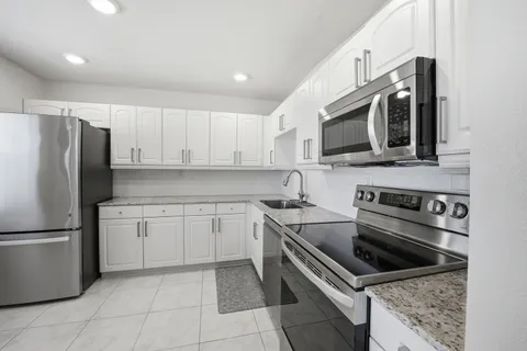 a kitchen with stainless steel appliances granite countertop a stove microwave and refrigerator