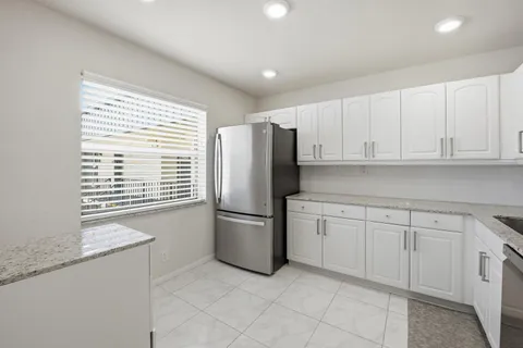 a kitchen with granite countertop white cabinets and stainless steel appliances