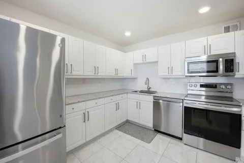 a kitchen with stainless steel appliances granite countertop a stove and a sink
