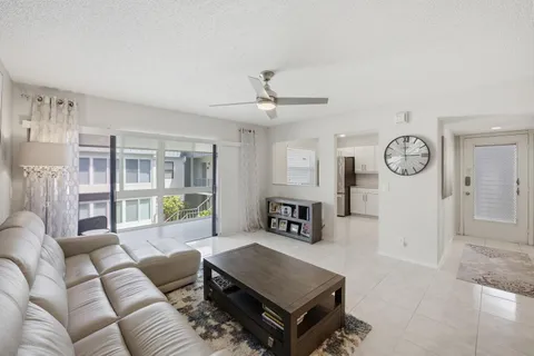 a living room with furniture a ceiling fan and a window