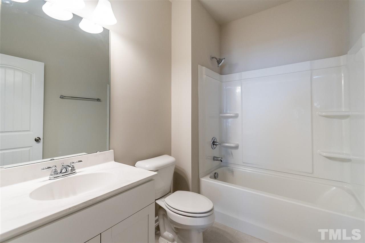 6339 Grace Lily Drive, Unit 18 Raleigh, NC 27607 - Photo 15 of 23 a bathroom with a sink toilet vanity and shower