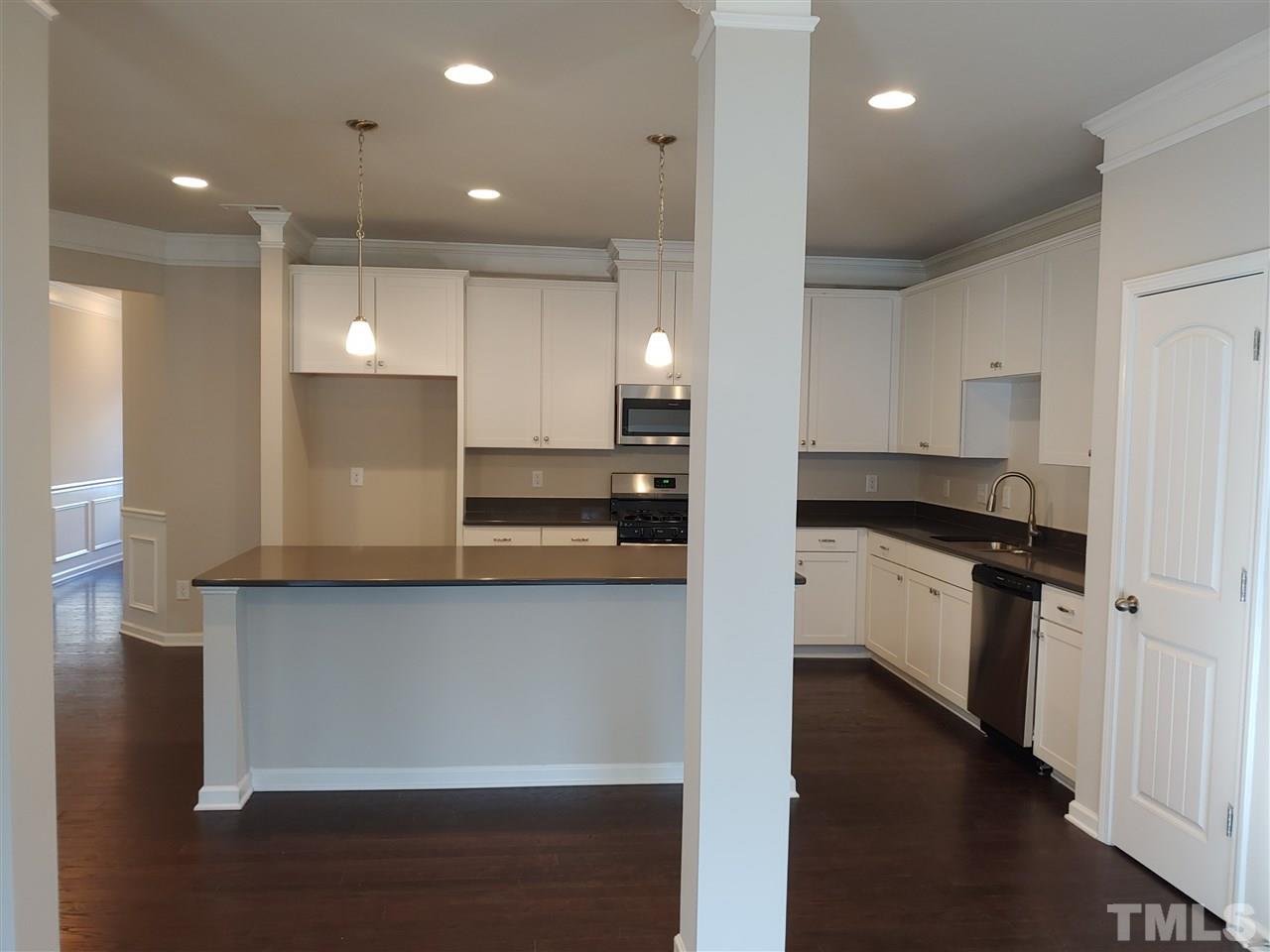6339 Grace Lily Drive, Unit 18 Raleigh, NC 27607 - Photo 4 of 23 a kitchen with stainless steel appliances granite countertop a refrigerator a sink and a stove