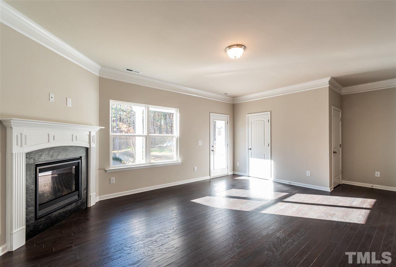 6339 Grace Lily Drive, Unit 18 Raleigh, NC 27607 - Photo 7 of 23 an empty room with wooden floor fireplace and windows