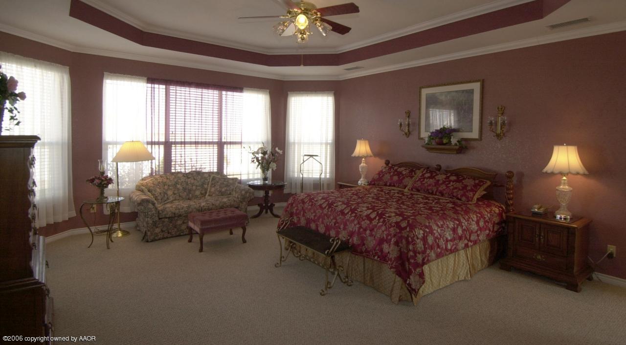8800 Red Wing Road Amarillo, TX 79119 - Photo 6 of 15 a bedroom with a bed and a chandelier