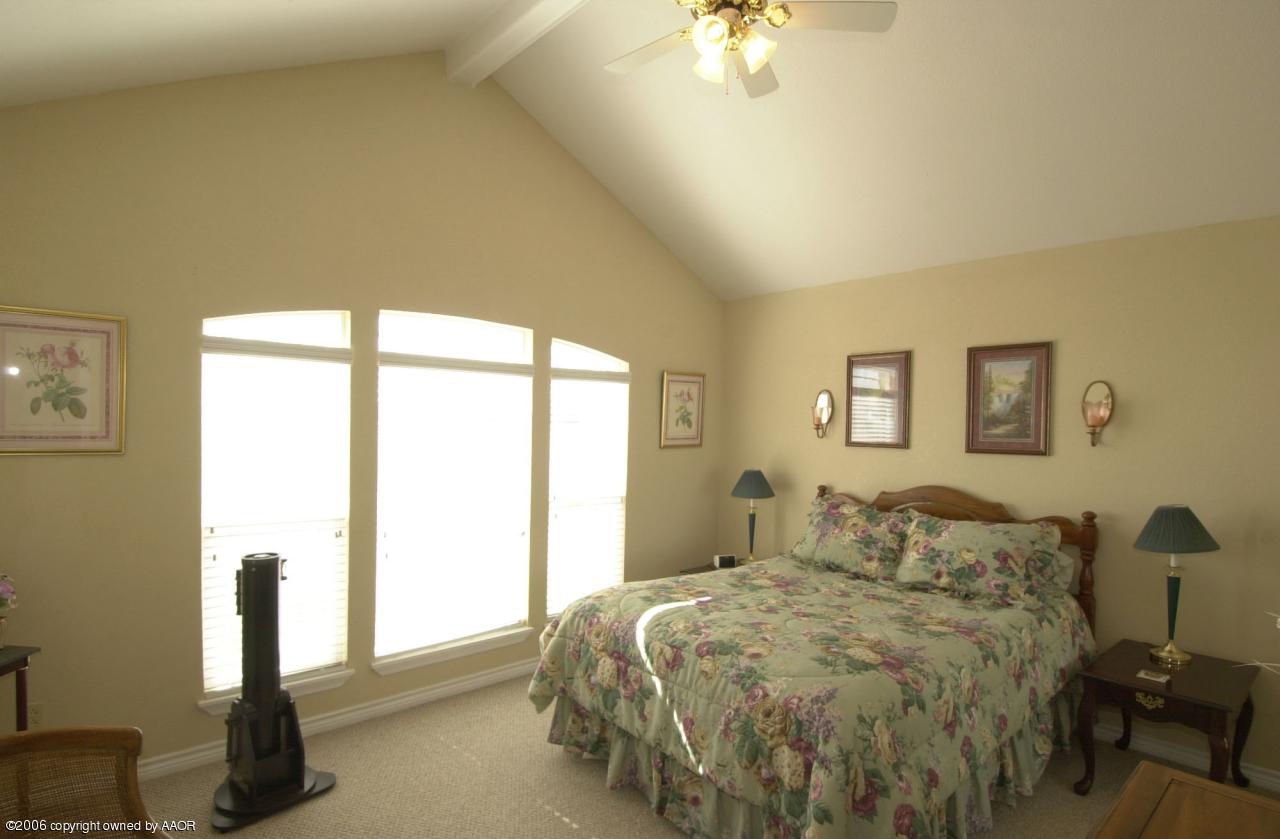 8800 Red Wing Road Amarillo, TX 79119 - Photo 10 of 15 a bedroom with a bed and a chandelier