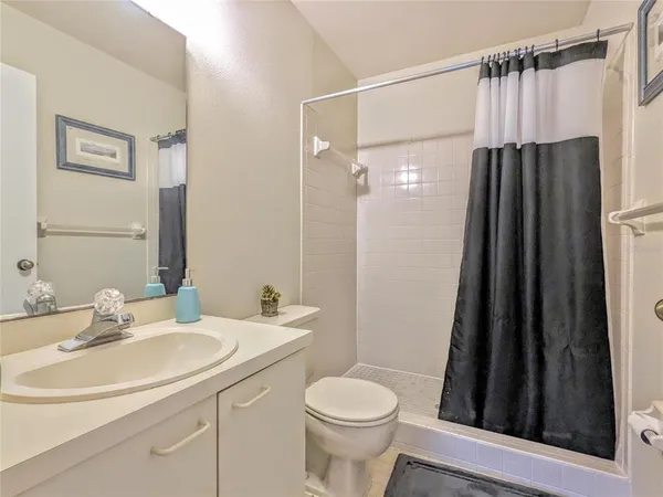a bathroom with a sink a toilet a mirror and shower