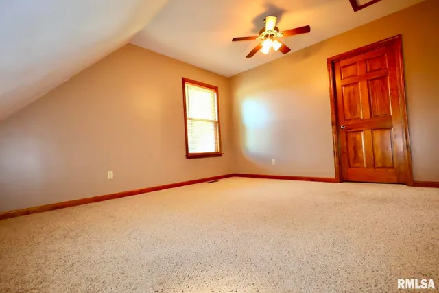 an empty room with a window and a ceiling fan