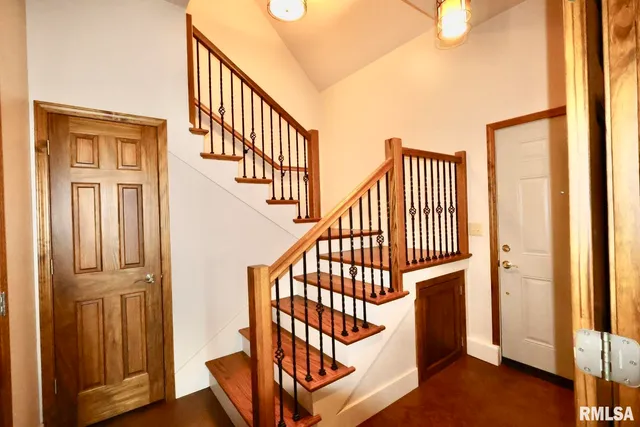 a view of staircase with railing and a rug