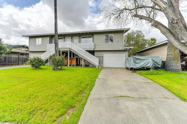 a front view of house with yard and green space