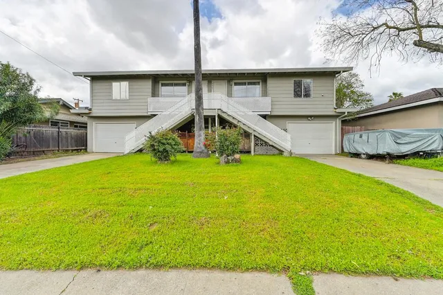 a view of a house with a yard and sitting area