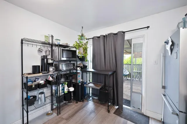 a kitchen with stainless steel appliances a refrigerator and a wooden floor