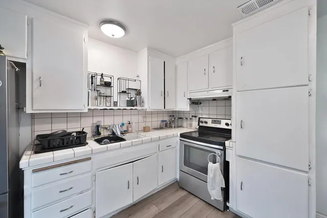 a kitchen with white cabinets and white appliances