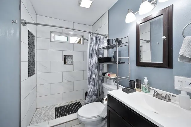 a bathroom with a sink a toilet and shower