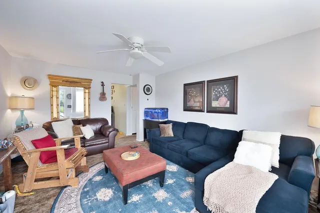 a living room with furniture a rug and a window