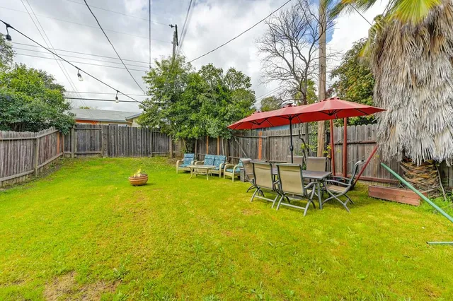 a view of a swimming pool with a table and chairs under an umbrella