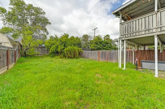 a view of a backyard with table and chairs and wooden fence