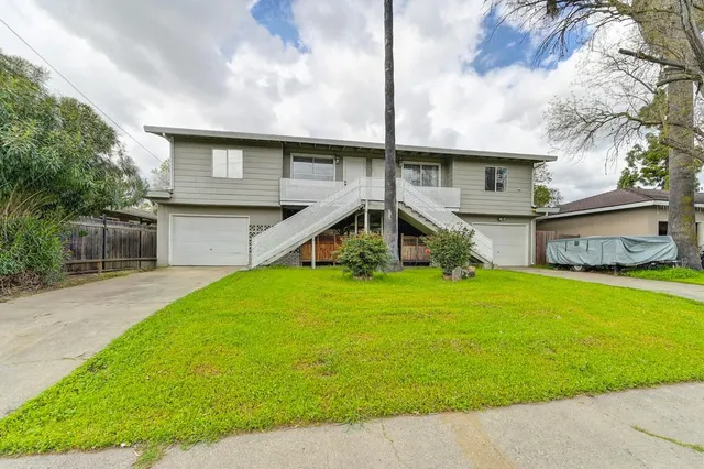 a front view of a house with a yard and trees
