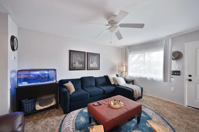 a living room with furniture a flat screen tv and a window