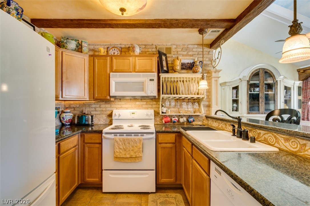 9325 West Desert Inn Road, Unit 244 Las Vegas, NV 89117 - Photo 23 of 55 A well-equipped kitchen boasts granite counters, classic wood cabinetry, and exposed ceiling beams.