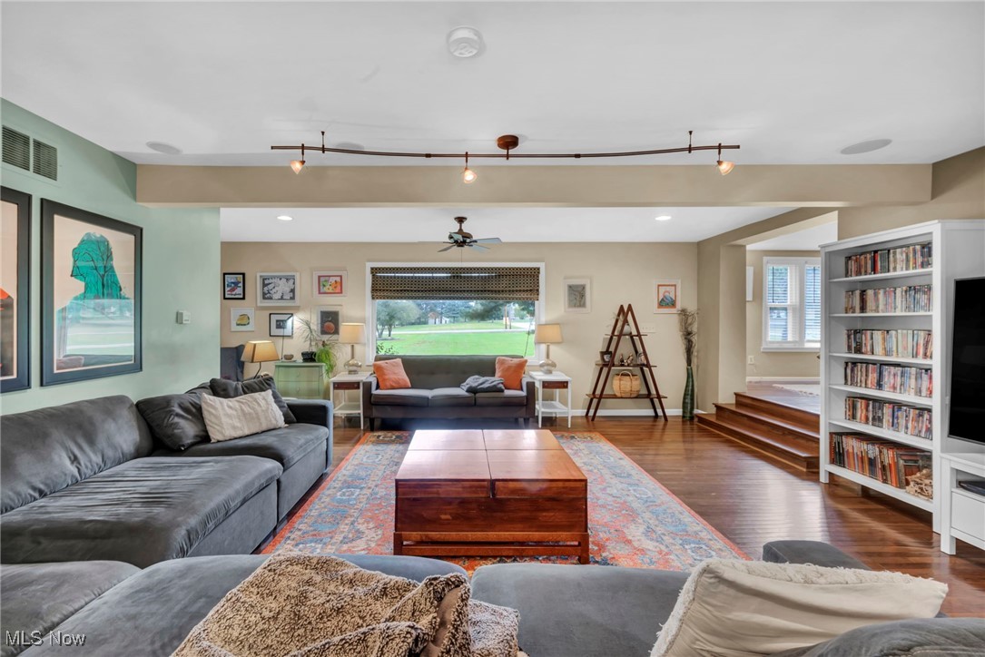 9083 Shepard Road Macedonia, OH 44056 - Photo 7 of 50 Living room featuring a ceiling fan, healthy amount of natural light, dark wood-style floors, stairway, and beam ceiling