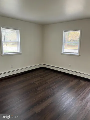 a view of a room that has wooden floor and window