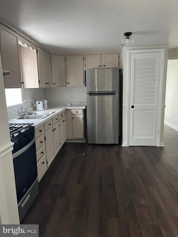 a kitchen with a sink a refrigerator a microwave and cabinets