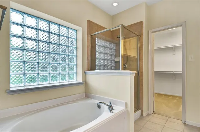 a bathroom with a bathtub and next to a window