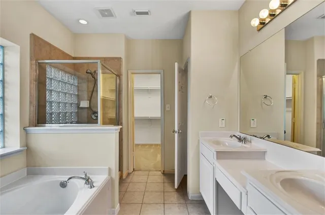 a bathroom with a tub a sink and mirror