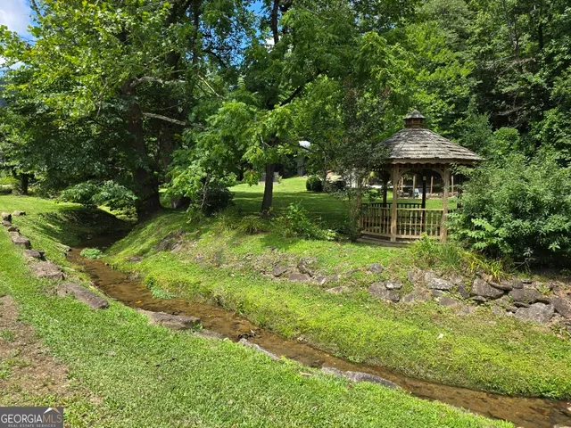 a backyard of a house with plants and tree