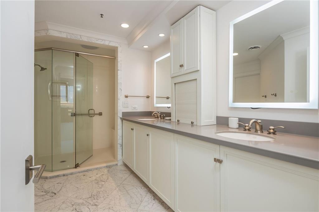 2660 Peachtree Road Northwest, Unit 22E Atlanta, GA 30305 - Photo 19 of 52 a bathroom with a double vanity sink mirror and shower