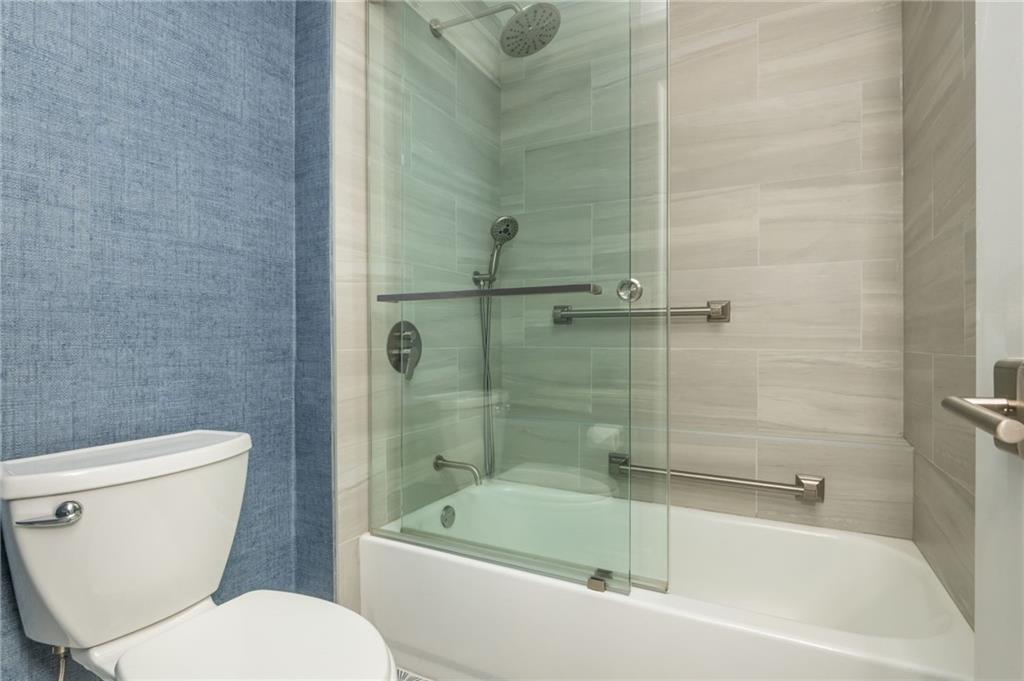 2660 Peachtree Road Northwest, Unit 22E Atlanta, GA 30305 - Photo 22 of 48 a white bath tub sitting next to a toilet