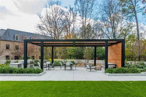 a patio with a table and chairs and potted plants