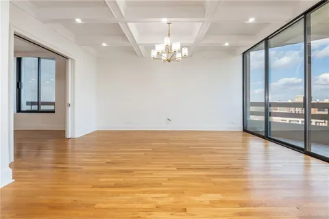 a view of a dining room with furniture a chandelier and wooden floor