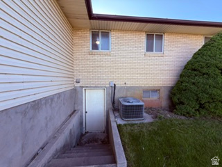 588 North 4500 West West Point, UT 84015 - Photo 57 of 61 Exterior featuring a secondary entry with concrete stairs, light-colored brick, horizontal siding, and a mature evergreen shrub