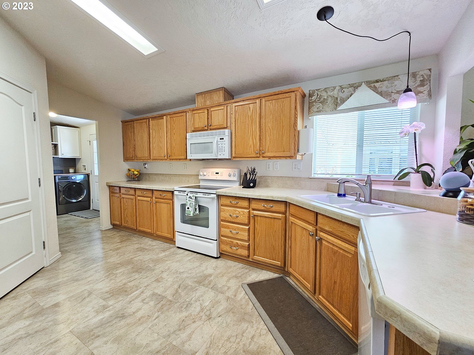12450 Southwest Fischer Road, Unit 142 Tigard, OR 97224 - Photo 16 of 35 a large kitchen with a stove a sink dishwasher and a refrigerator